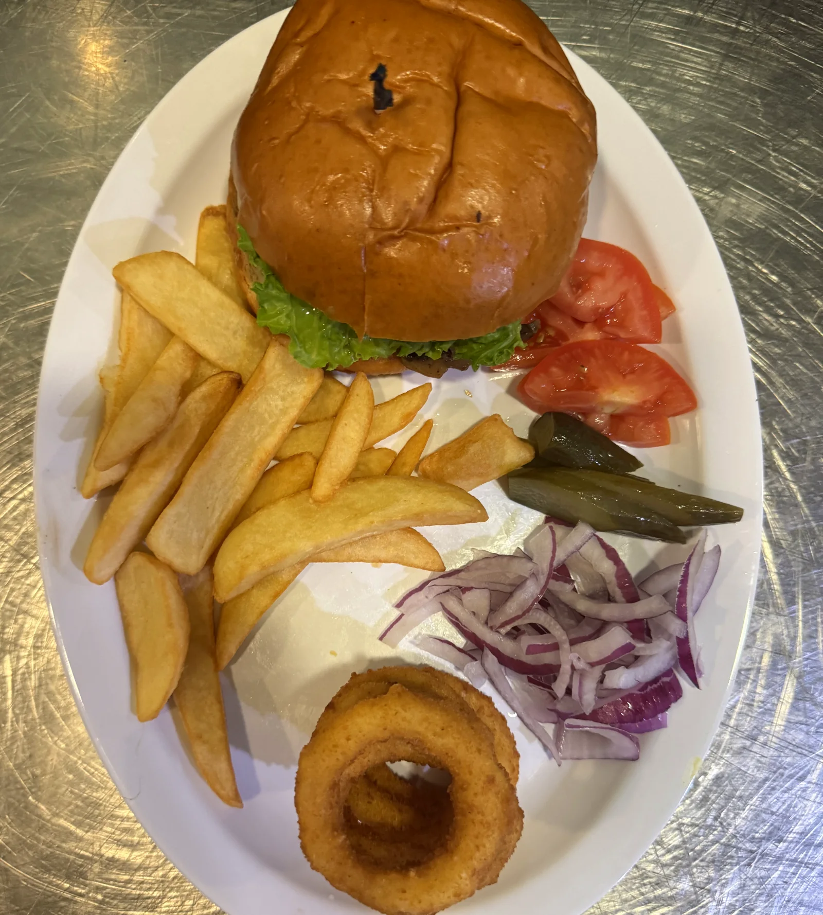 Persian Cheese Burger, Served on a brioche bun with tomato, lettuce, onion and your choice of cheese with Darband sauce, with a side of fries.