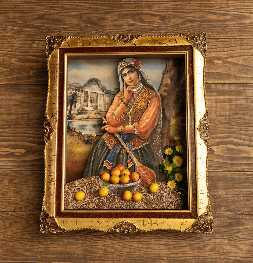 A framed Persian painting on the wood wall at Darband: a woman with a bowl of fruit